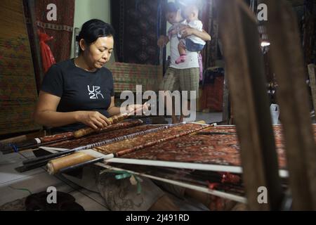 Ni Wayan Sudiati, a weaving artist, is working at her workshop in the traditional village of Tenganan Pegringsingan in Karangasem, Bali, Indonesia. Stock Photo