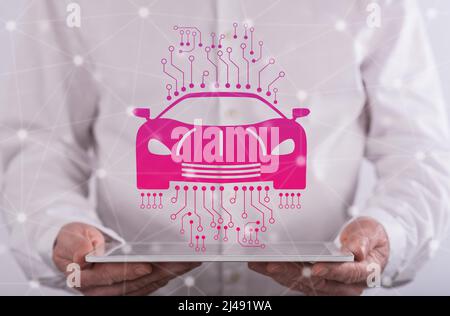 Smart car concept above a tablet held by a man in background Stock Photo