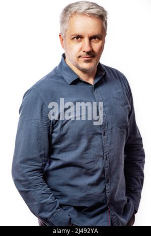 Portrait of a bearded middle-aged man looking thoughtfully at the camera over a white studio background with copy space Stock Photo