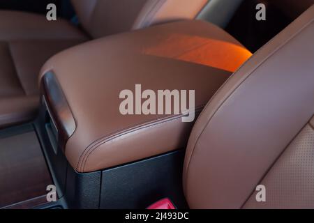 Armrest in the driver's car is upholstered in eco-leather. Beautiful leather car interior design. Luxury leather seats in car. Brown leather seat cove Stock Photo