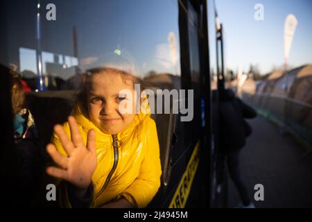 Przemysl, Poland. 13th Apr, 2022. A girl who fled Ukraine with family members waits in a bus at the Medyka border crossing, just across the Ukrainian border on the Polish side, in the morning for the onward journey. Credit: Christoph Soeder/dpa/Alamy Live News Stock Photo