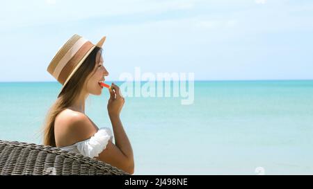 Young woman eating watermelon, turquoise sea, summer vacations holidays concept Stock Photo
