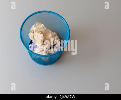 Waste paper basket filled with crumpled papers Stock Photo