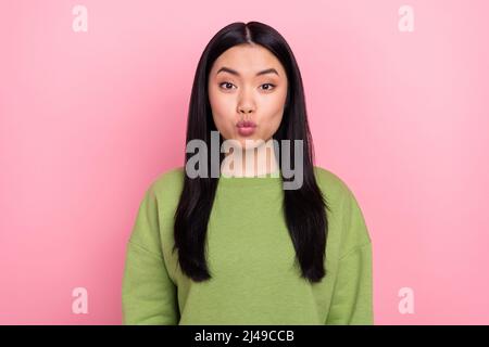 Photo of flirty brunette young lady blow kiss wear green sweater isolated on pink color background Stock Photo