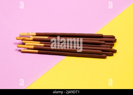 Chocolate covered stick on purple and yellow background Stock Photo