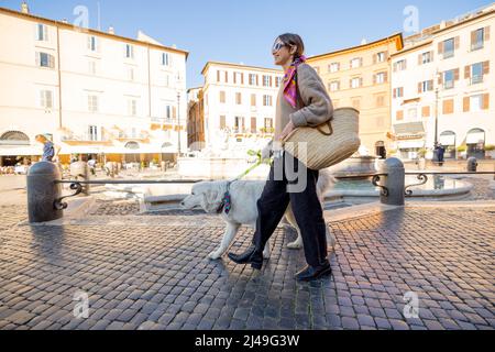 Woman walks with italian shepherd dog on Navona square in Rome Stock Photo