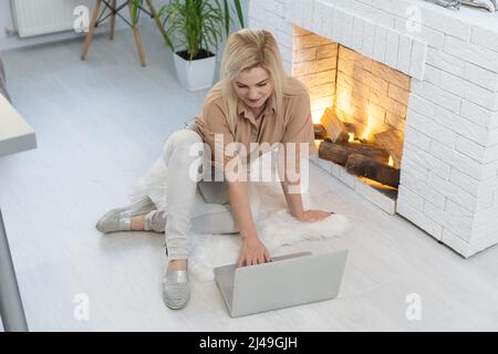 Bored woman resting and lying on couch take break, watching movie, working on laptop at home in living room. Lazy weekend. Stock Photo