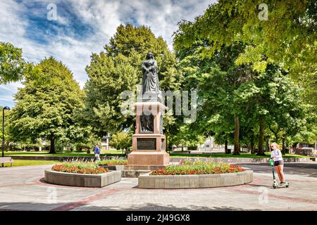 3 January 2019: Christchurch, New Zealand - Victoria Square in summer, with trees in full leaf, statue of Queen Victoria, and a young girl riding an... Stock Photo