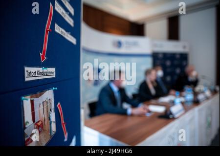 13 April 2022, North Rhine-Westphalia, Bochum: An information board reads 'Crime scene children's room' while Ralf Gromann (l-r), Head of the Criminal Investigation Directorate PP Bochum, Stefanie Lienemann, Head of the Investigation Group PP Bochum, Dietrich Streßig, Public Prosecutor's Office Bochum, and Frank Lemanis, Head of the Press Office PP Bochum, sit at the press conference. Public prosecutor's office and police report in a press conference on the arrest of a 33-year-old woman from Herne. The woman is strongly suspected of having intentionally killed her two biological children, then Stock Photo