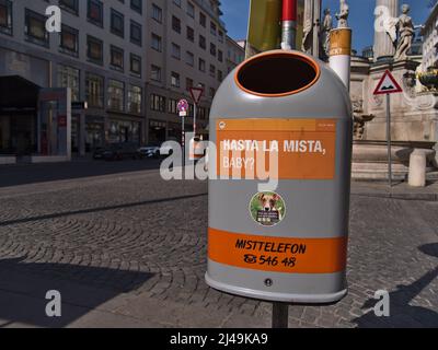 Close-up view of a grey and orange colored dustbin in the historic center of Vienna, Austria with funny slogan (Hasta La Mista, Baby?). Stock Photo