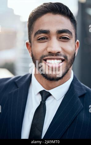 Success looks good on me. Shot of a handsome young businessman standing alone outside. Stock Photo