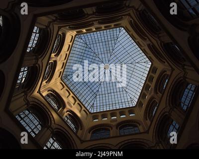 Low angle view of the inner courtyard of popular building Palais Ferstel in the historic center of Vienna, Austria with glass roofing. Stock Photo