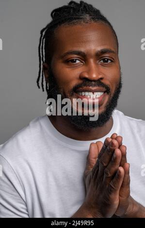 Smiling pleased guy showing his anticipation with hand-rubbing gesture Stock Photo