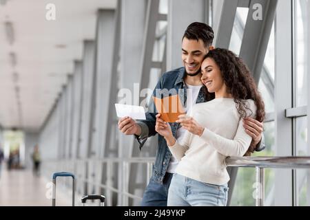 Travel Insurance Concept. Happy Young Arab Couple Waiting For Flight At Airport Stock Photo