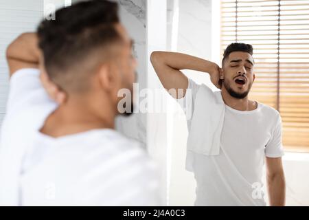 Lazy Morning. Portrait Of Sleepy Young Arab Man Yawning In Bathroom Stock Photo