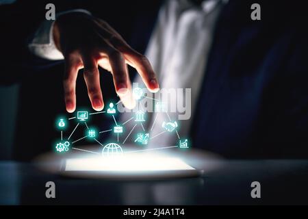 Advancing into a futuristic business world. Cropped shot of an unrecognizable businessman working alone in the office at night and using a digital Stock Photo
