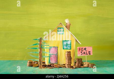 Buying house,real estate business concept.Cute model home with stacks of coins. Free copy space Stock Photo