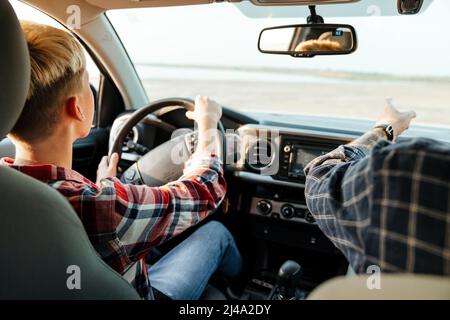 Happy middle aged father and his preschooler son sitting in a car driving car back view Stock Photo