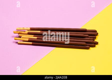 Chocolate covered stick on purple and yellow background Stock Photo