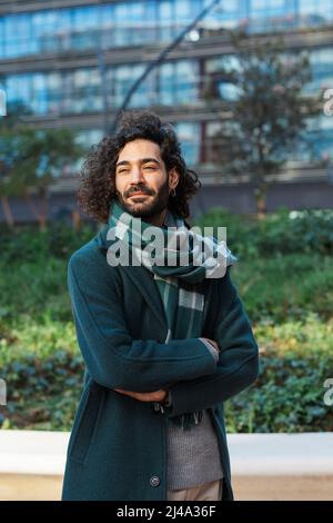 Businessman looking away while standing with his arms crossed on the street at financial district. Stock Photo