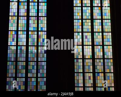 Beautiful view of the colorful glass window of a church with dark frames and sunlight shining through. Stock Photo