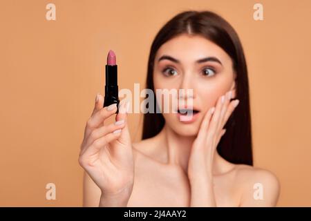 young happy positive woman holding pink lipstick Stock Photo