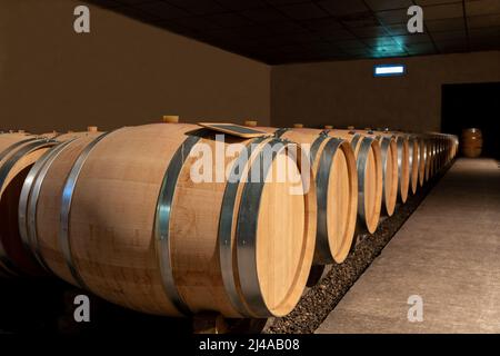 Barrels of Bordeaux wine in a Medoc cellar, in Gironde Stock Photo