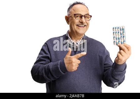 Mature man holding a pack of pills and pointing isolated on white background Stock Photo