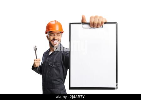 Worker with a helmet holding a wrench and showing a blank paper on a clipboard isolated on white background Stock Photo