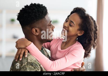 Cute black girl enjoying reunion with her father soldier Stock Photo