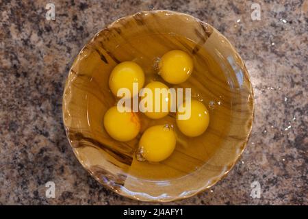 closeup of a bowl with cracked chicken eggs in a kitchen worktop Stock Photo