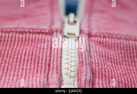 Worn, faded red jacket with zipper, close up Stock Photo