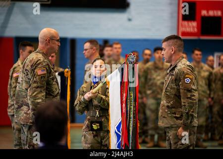 Ansbach, Germany. 5th Apr, 2022. Maj. Gen. Robert Burke, deputy commanding general of support, V Corps, and Sgt. Maj. Mike Lamkins, operations sergeant major, V Corps, unfurls the unit colors during a welcome ceremony at Barton Barracks in Ansbach, Germany, Tuesday, April 5. During the ceremony, the V Corps headquarters and the headquarters and headquarters battalion uncased their colors at their temporary home. The presence of the entire Victory Corps headquarters in Europe expands U.S. Army Europe and Africas ability to command land forces in Europe and sends a strong message to our NATO a Stock Photo