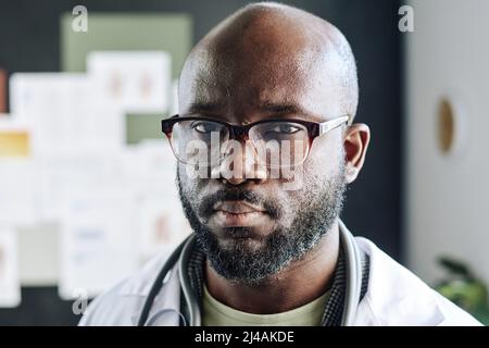 Close-up of African male doctor in eyeglasses looking at camera with serious expression Stock Photo