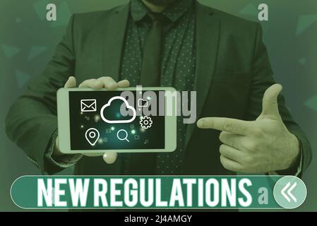 Text showing inspiration New Regulations. Business overview Regulation controlling the activity usually used by rules. Man holding Screen Of Mobile Stock Photo