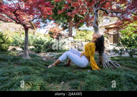 Powerful Portrait of a Beautiful Young Black Woman Under Japanese Maple Tree Stock Photo