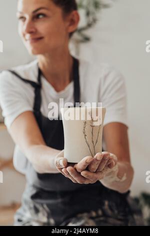 Female Ceramist Artist Holding in Hand a Handmade Crafted Cup Stock Photo