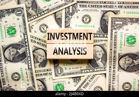 Investment analysis symbol. Wooden blocks with concept words Investment analysis on beautiful background from dollar bills. Business investment analys Stock Photo
