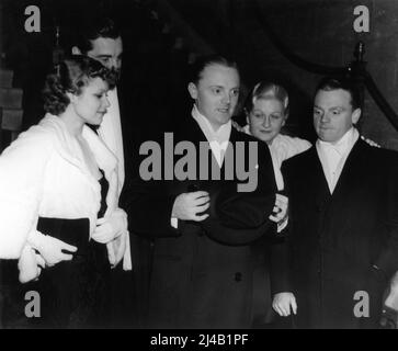 BOOTS MALLORY and her husband WILLIAM CAGNEY and JAMES CAGNEY and his wife BILLIE / FRANCES CAGNEY with PHIL REGAN partially obscured arriving at at Warner Bros. Sales Banquet in Hollywood in 1934 Stock Photo