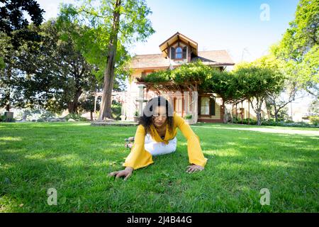 Portrait of a Vibrant Young Black Woman in Front of an Old Victorian House Stock Photo