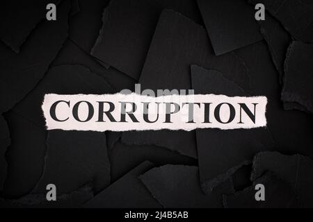 Torn pieces of black paper with the word Corruption. Concept Image. Close up. Stock Photo