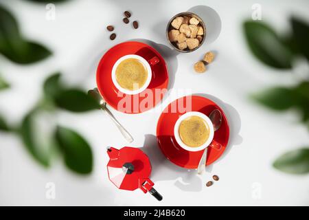 Coffee composition on light grey background with green branches, flat lay, top view Stock Photo