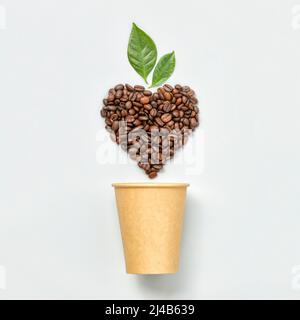 White coffee cup and coffee beans in shape of heart on white background, top view Stock Photo