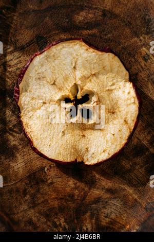 Close up of a thin slices of dried apple fruit, on a wooden table Stock Photo