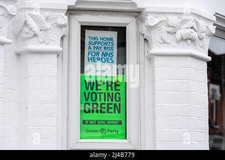 Posters in the window of a residential property relating to forthcoming local elections. Supporting the Green Party and NHS pay rise Stock Photo