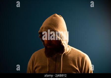 man with hood on a dark background depression or hacker Stock Photo