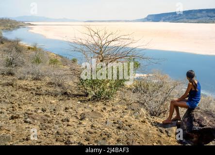 Woman looking at Lake Magadi salt lake Kenya Stock Photo