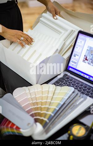 Khabarovsk, Russia, Desember 16, 2021. Closeup female interior designer hands choosing furniture material and color samples working studio Stock Photo