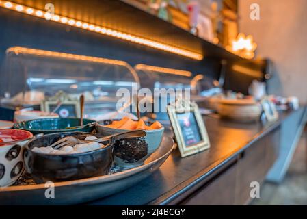 Assorted fresh food served in bowls on counter for lunch at restaurant Stock Photo