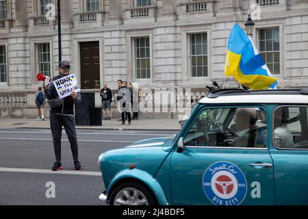 London, UK. 13th Apr, 2022. A protester holds a sign asking the drivers to honk and support Ukraine while driving down Whitehall. Ukrainian supporters gather in Central London on a daily basis to protest against Russian invasion of Ukraine since 24th February 2022. They continue to demand NATO to close the air space above Ukraine to stop Russia from bombing the country and send arms to support Ukrainian army. (Photo by Hesther Ng/SOPA Images/Sipa USA) Credit: Sipa USA/Alamy Live News Stock Photo